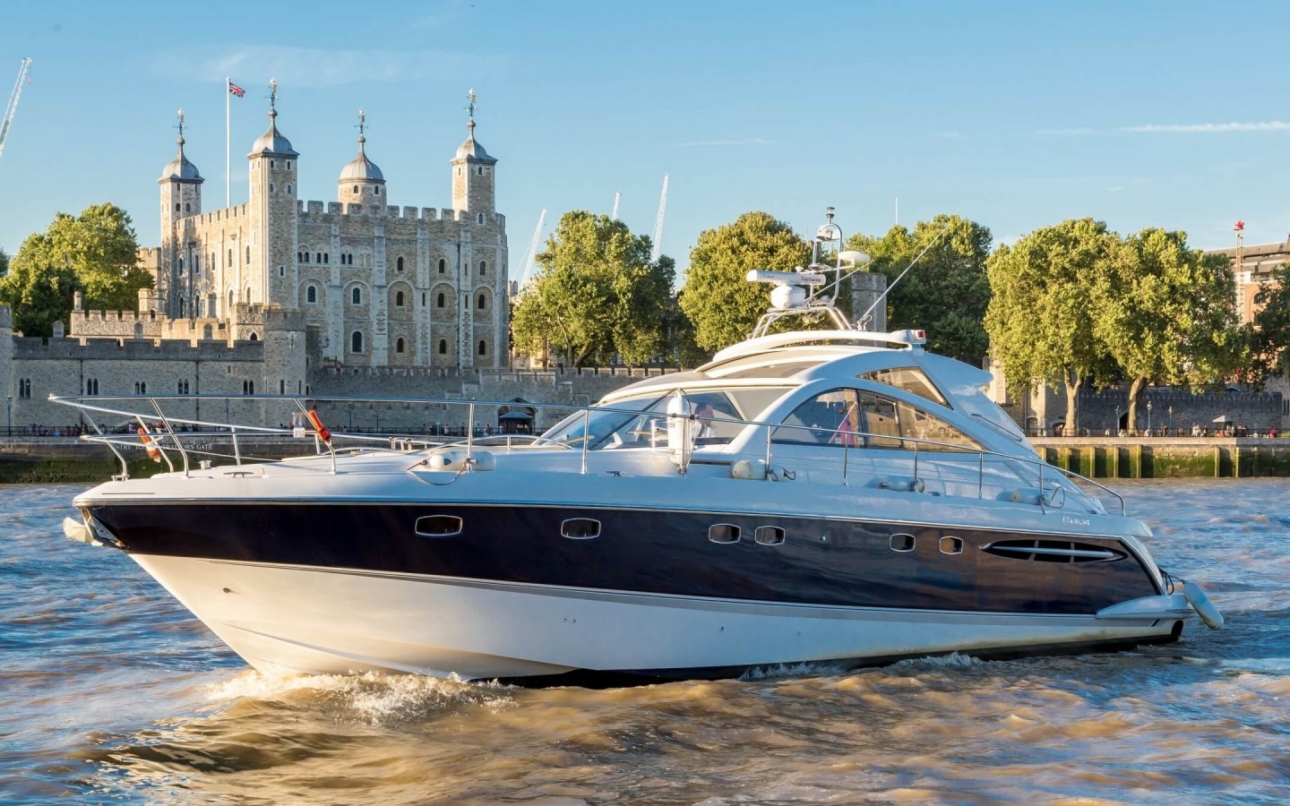 Luxury motor yacht on the River Thames, London with the Tower of London in the background