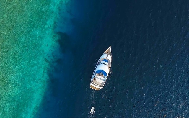 motor yacht in sea off the Maldives from above